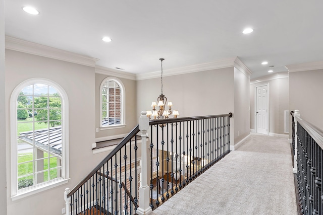 hall featuring ornamental molding, a chandelier, and light colored carpet