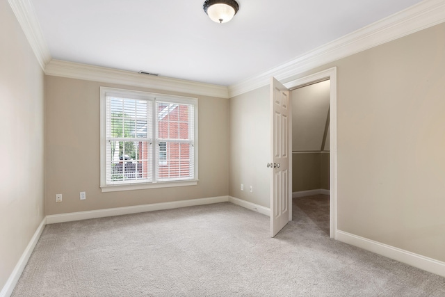 spare room with ornamental molding and light colored carpet