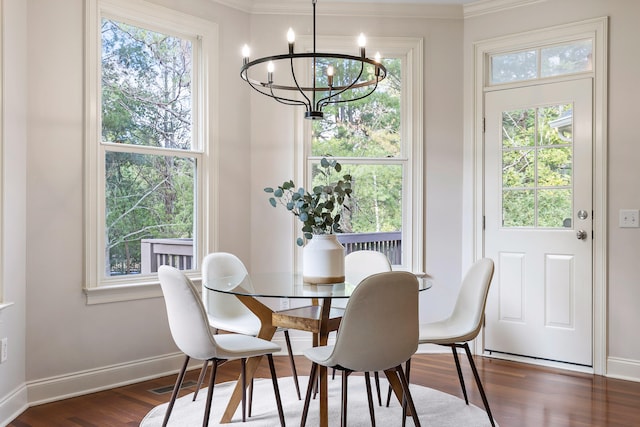 dining room featuring dark hardwood / wood-style floors, a healthy amount of sunlight, and an inviting chandelier