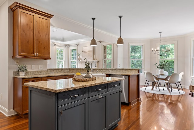 kitchen featuring dark wood-type flooring, dishwasher, a center island, decorative light fixtures, and a healthy amount of sunlight