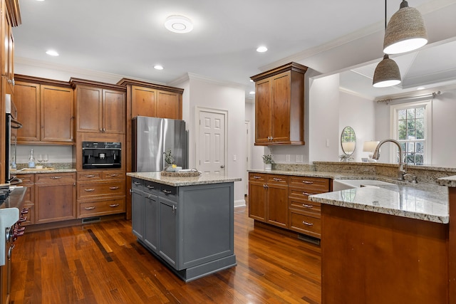 kitchen with pendant lighting, sink, stainless steel refrigerator, dark hardwood / wood-style floors, and a center island