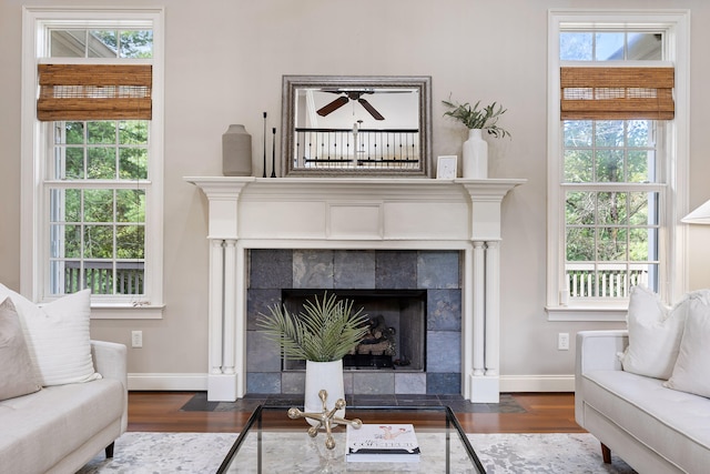 living room with a tile fireplace and dark hardwood / wood-style flooring