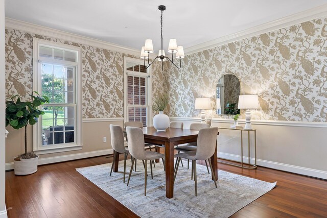 dining area featuring a notable chandelier, crown molding, and dark hardwood / wood-style flooring