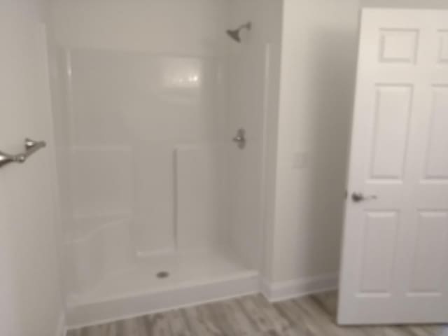 bathroom featuring wood-type flooring and a shower