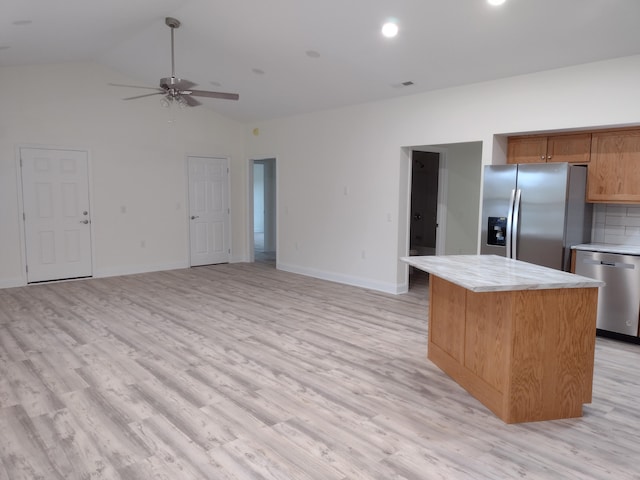 kitchen featuring ceiling fan, lofted ceiling, a kitchen island, stainless steel appliances, and light wood-type flooring