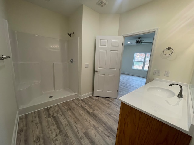 bathroom featuring vanity, a shower, and hardwood / wood-style flooring