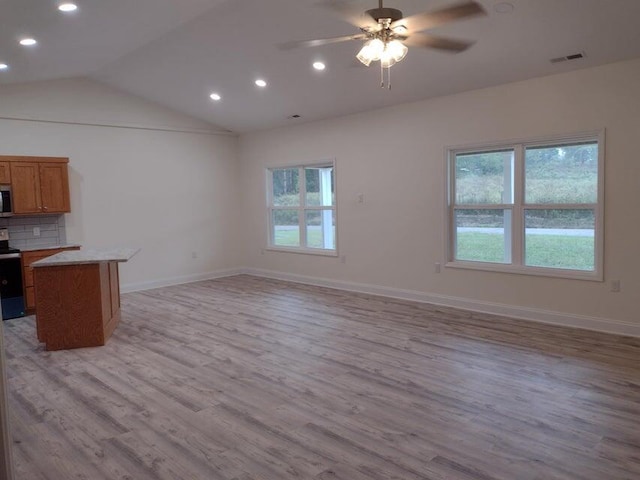 kitchen with ceiling fan, lofted ceiling, light hardwood / wood-style floors, and a wealth of natural light