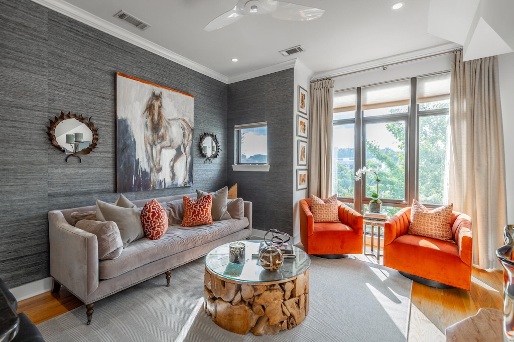 living room with ornamental molding, wood-type flooring, and ceiling fan