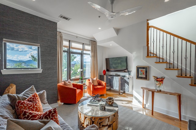 living room featuring ornamental molding, ceiling fan, and light hardwood / wood-style flooring