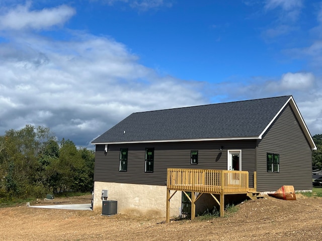 rear view of property featuring cooling unit and a deck