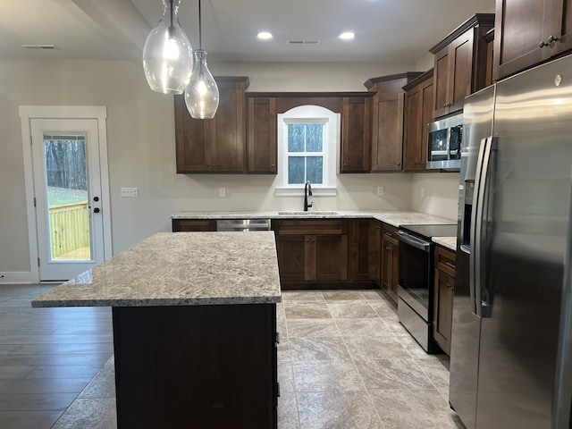 kitchen with sink, dark brown cabinets, stainless steel appliances, and a kitchen island