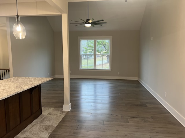 unfurnished dining area with ceiling fan, lofted ceiling, and dark hardwood / wood-style flooring