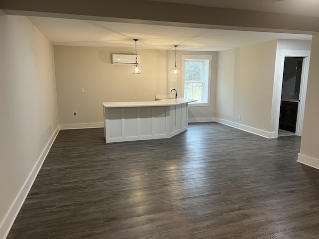 bar featuring dark wood-type flooring, sink, hanging light fixtures, and an AC wall unit