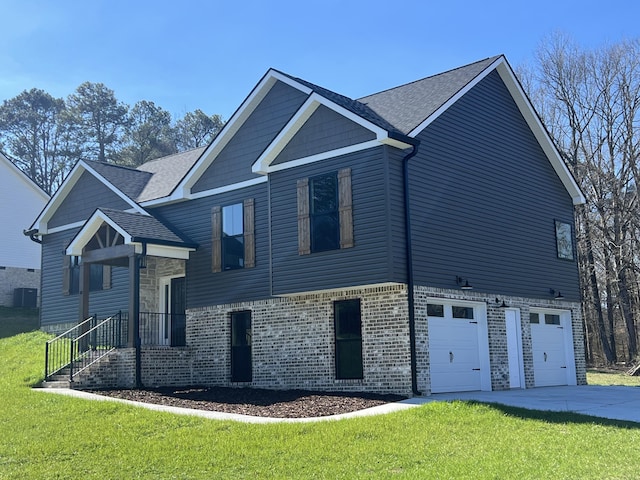 view of front of property with a garage, a front yard, and central AC unit