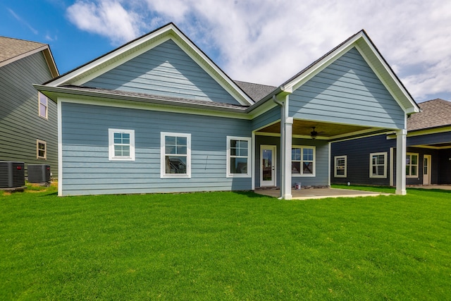 rear view of property featuring ceiling fan, a lawn, and a patio area