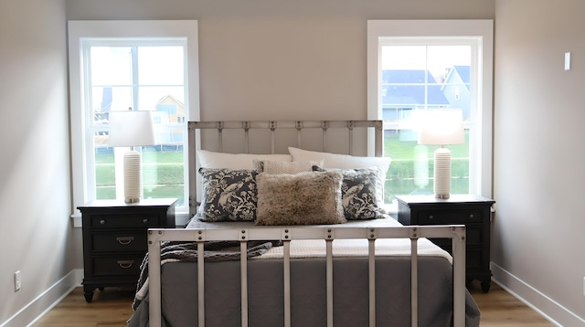 bedroom featuring multiple windows and light hardwood / wood-style floors