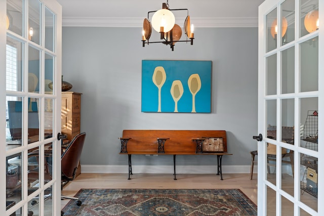 interior space featuring hardwood / wood-style floors, a notable chandelier, crown molding, and french doors