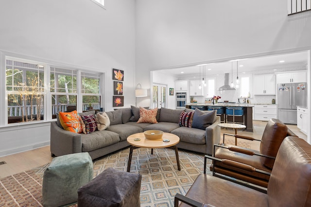 living room featuring a high ceiling and light hardwood / wood-style floors