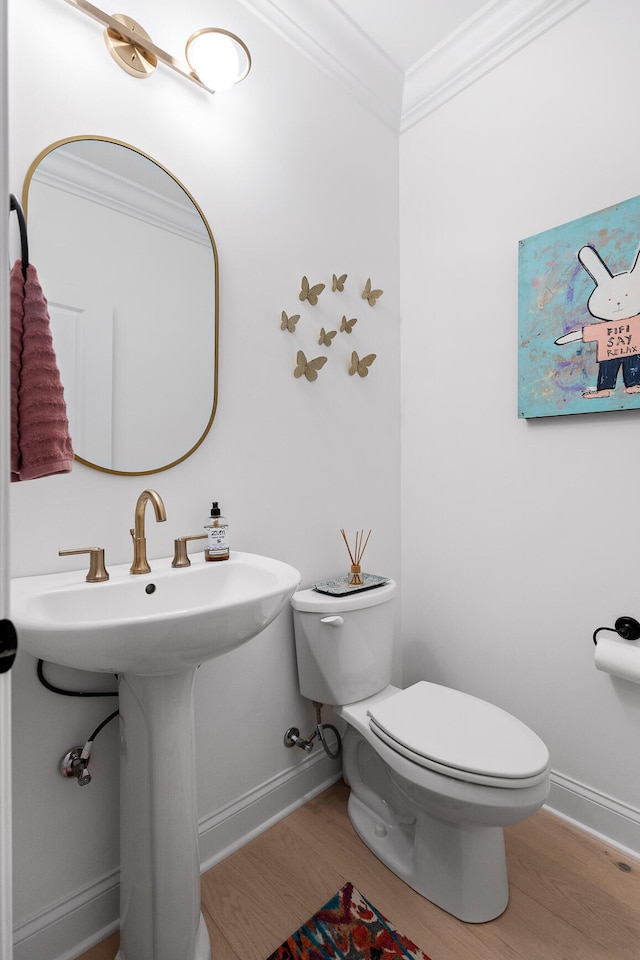 bathroom with sink, toilet, wood-type flooring, and ornamental molding