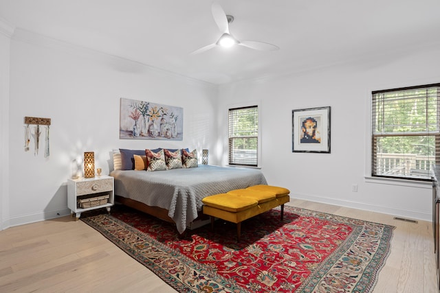 bedroom featuring ceiling fan, crown molding, and light wood-type flooring