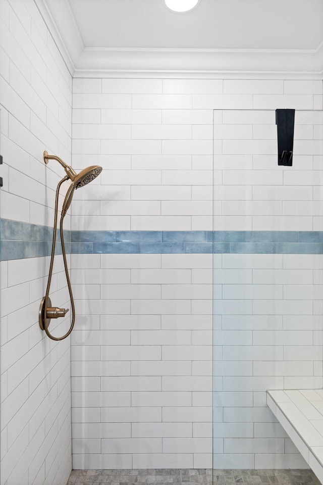 bathroom featuring a tile shower and ornamental molding