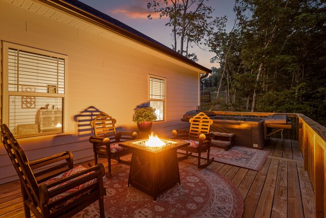 deck at dusk with a hot tub and an outdoor living space with a fire pit