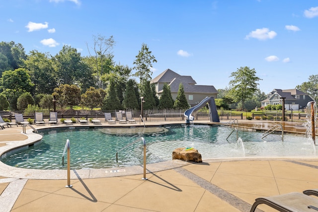 view of swimming pool with pool water feature, a patio area, and a water slide