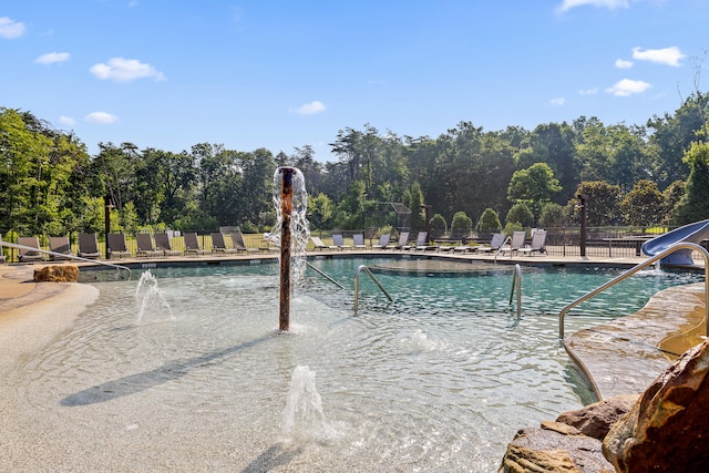 view of pool with pool water feature and a patio