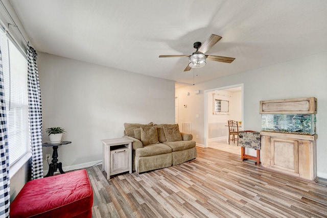 living room with light wood-type flooring and ceiling fan