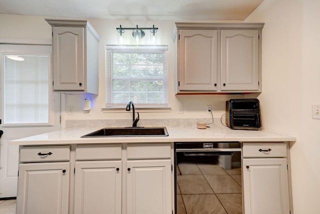 kitchen featuring light tile patterned flooring, a wealth of natural light, sink, and dishwasher