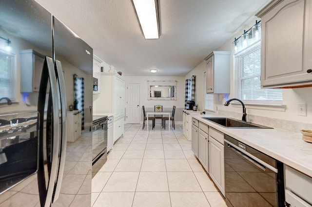 kitchen with black appliances, sink, and light tile patterned floors