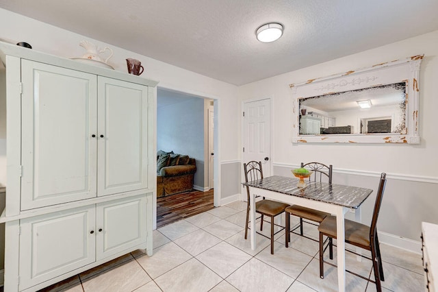 dining room with light tile patterned flooring and a textured ceiling