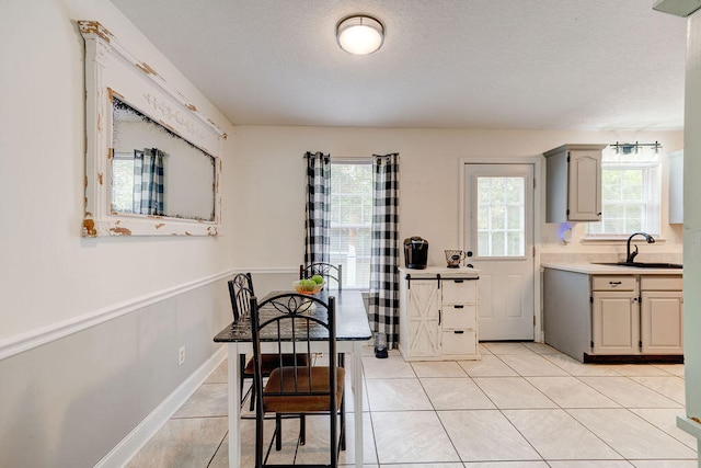 tiled dining space featuring a textured ceiling and sink