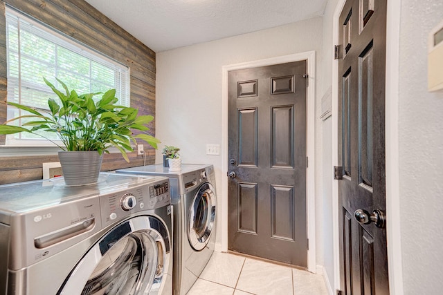 laundry room with independent washer and dryer, light tile patterned floors, and a textured ceiling