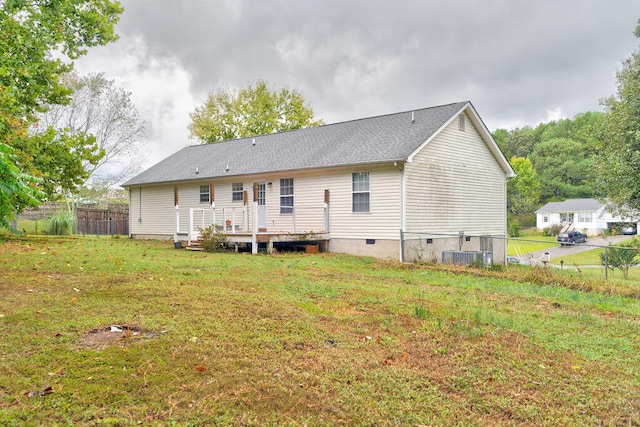 rear view of property with a wooden deck and a yard