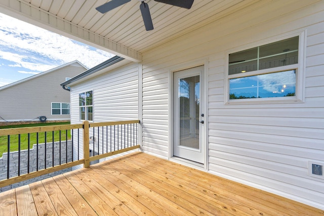 wooden deck with ceiling fan and a lawn