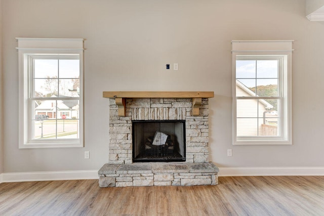 details with a stone fireplace and wood-type flooring