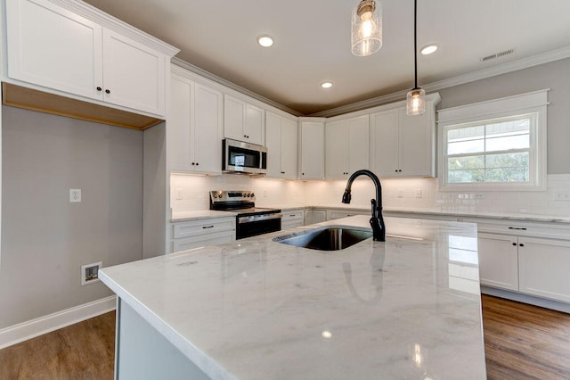 kitchen featuring white cabinetry, sink, pendant lighting, and appliances with stainless steel finishes