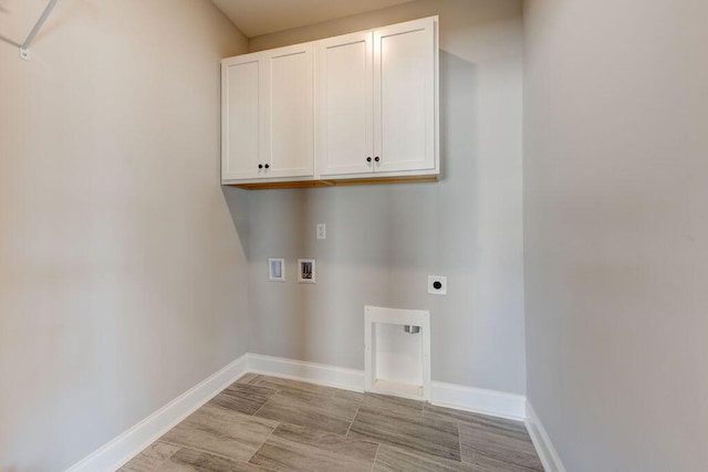 washroom featuring hookup for an electric dryer, cabinets, and washer hookup