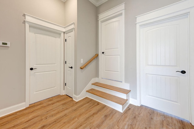 stairs featuring hardwood / wood-style floors and ornamental molding