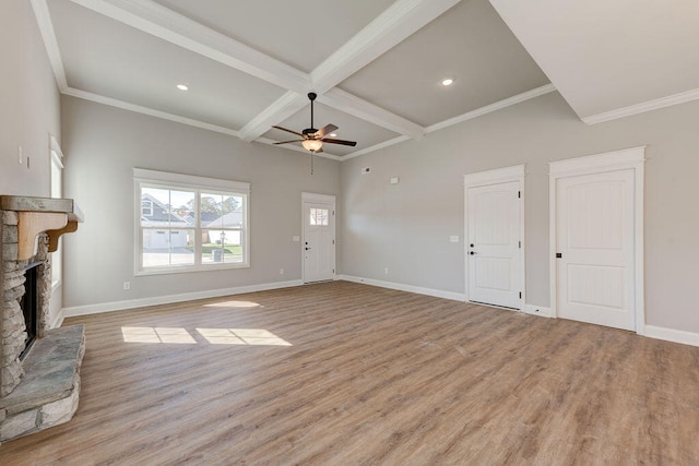 unfurnished living room with ceiling fan, a stone fireplace, beamed ceiling, crown molding, and light wood-type flooring