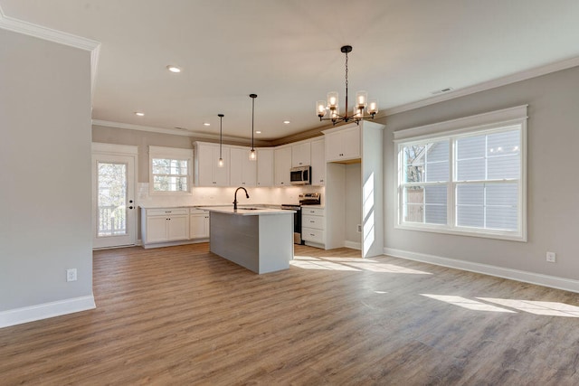 kitchen featuring light hardwood / wood-style flooring, pendant lighting, a kitchen island with sink, white cabinets, and appliances with stainless steel finishes