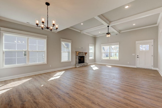 unfurnished living room featuring ceiling fan with notable chandelier, a stone fireplace, crown molding, light wood-type flooring, and beam ceiling