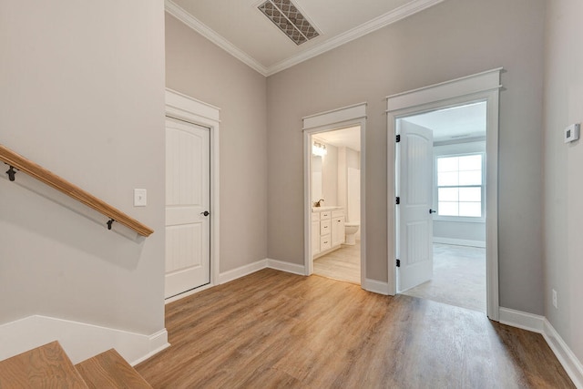 entrance foyer with crown molding and light hardwood / wood-style floors