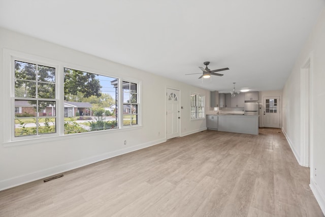 unfurnished living room featuring light wood-type flooring and ceiling fan