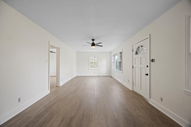 unfurnished room with ceiling fan and dark wood-type flooring