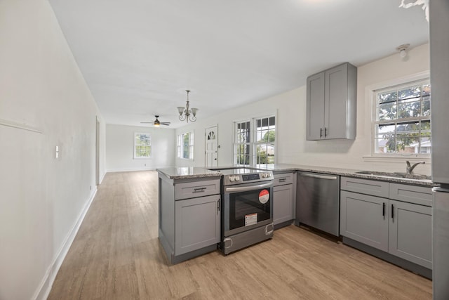 kitchen featuring ceiling fan, kitchen peninsula, gray cabinets, appliances with stainless steel finishes, and light hardwood / wood-style floors