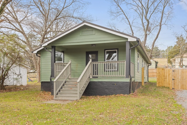 bungalow with covered porch and a front lawn