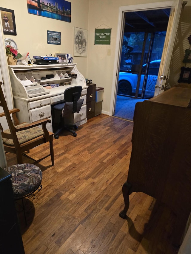 office featuring built in desk and hardwood / wood-style floors