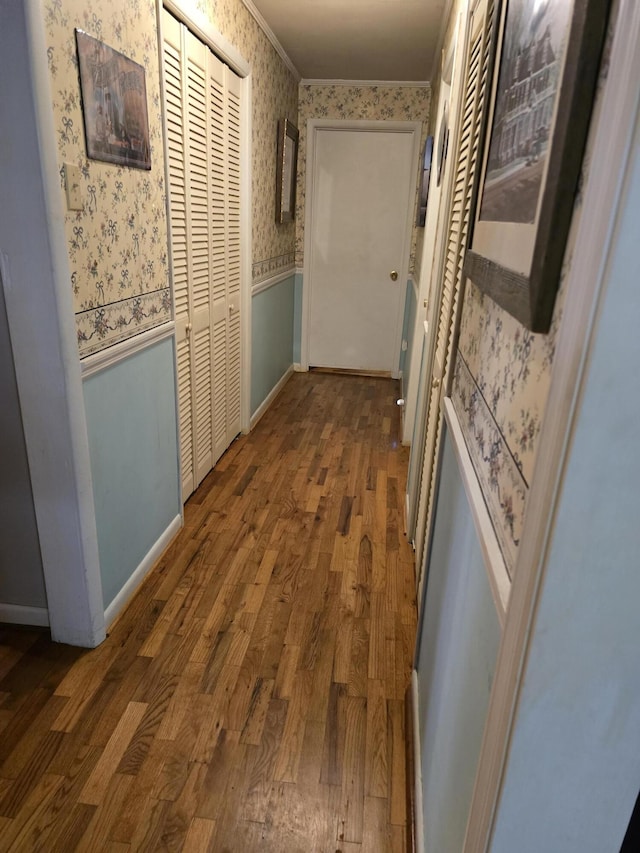 hall with ornamental molding and wood-type flooring